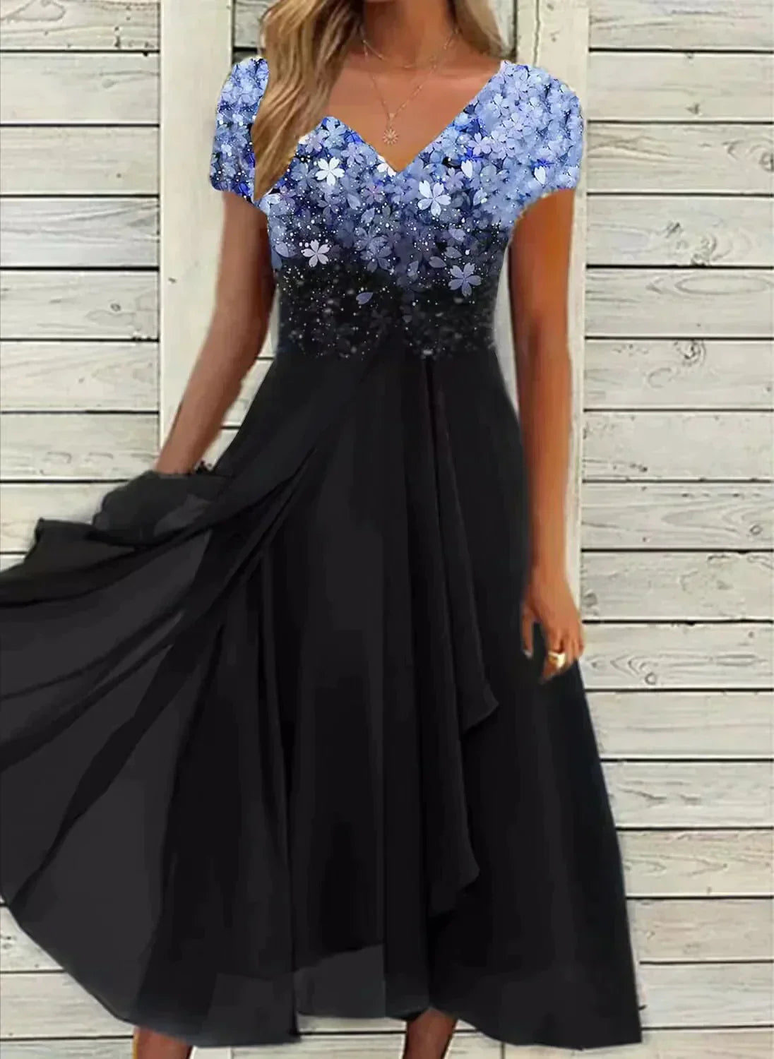 Elegant black evening dress with a floral-patterned blue sequin top, V-neckline, and flowing skirt, perfect for formal occasions and parties.