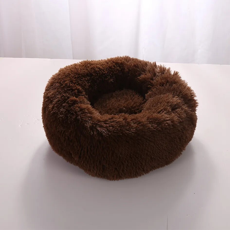 Brown fluffy pet bed on a white surface, ideal for cats and small dogs. Cozy, round design for comfort and warmth. Perfect for pet relaxation.