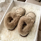 Cozy beige fur-lined slippers in a gift box, perfect for winter warmth. Soft, plush design ideal for indoor comfort. Great holiday gift idea.