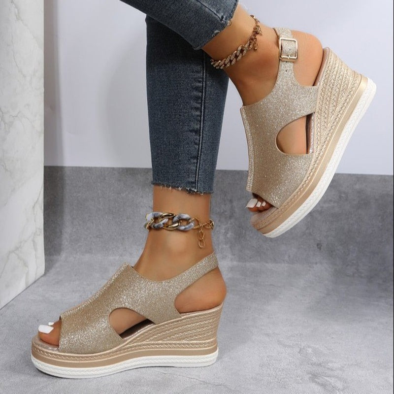 Gold glitter wedge sandals with open toe and ankle strap, paired with skinny jeans and anklets. Stylish women's footwear for summer fashion.