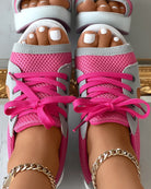 Pink mesh open-toe sneakers with white soles and laces, featuring gold ankle bracelets. Fashionable women's footwear, trendy summer style.