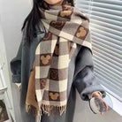 Plaid scarf with Mickey Mouse pattern in brown and beige tones, worn over a gray coat. Cozy winter fashion accessory, perfect for cold weather.