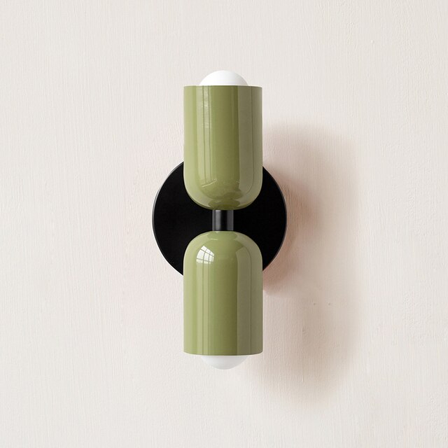 Modern green wall sconce with dual cylindrical lights on a black base, minimalist design, perfect for contemporary home lighting decor.