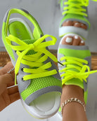 Neon green mesh sneakers with gray accents, open toe design, and vibrant yellow laces. Trendy women's footwear, perfect for casual summer style.