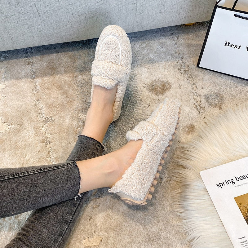 Cozy fleece-lined slip-on loafers with textured sole, perfect for casual wear. Women's fashion footwear on a plush carpet, ideal for winter comfort.