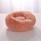 Fluffy pink pet bed on white background, round and plush, ideal for cats and small dogs. Cozy, soft, and comfortable pet sleeping accessory.