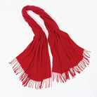 Red cashmere scarf with fringed edges on a white background, perfect for winter fashion. Luxurious, soft, and warm accessory for stylish outfits.