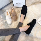 Women's cozy fleece loafers in black, beige, and cream displayed on a plush rug. Comfortable slip-on shoes perfect for casual wear and lounging.