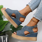 Blue wedge sandals with cutout design and ankle strap, paired with frayed hem jeans. Fashionable summer footwear for women.