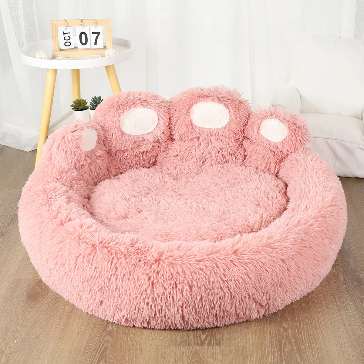 Pink fluffy pet bed shaped like a paw, cozy and soft, perfect for cats and small dogs.
