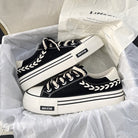 Black and white platform sneakers with braided laces in a box, featuring "BER STAR" branding. Trendy casual footwear for fashion-forward style.