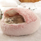 Fluffy pink cat bed with a cozy design, featuring a relaxed cat inside, perfect for pet comfort.