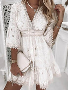 Elegant white lace dress with intricate embroidery, V-neckline, and bell sleeves. Perfect for summer fashion, boho style, and casual chic outfits.
