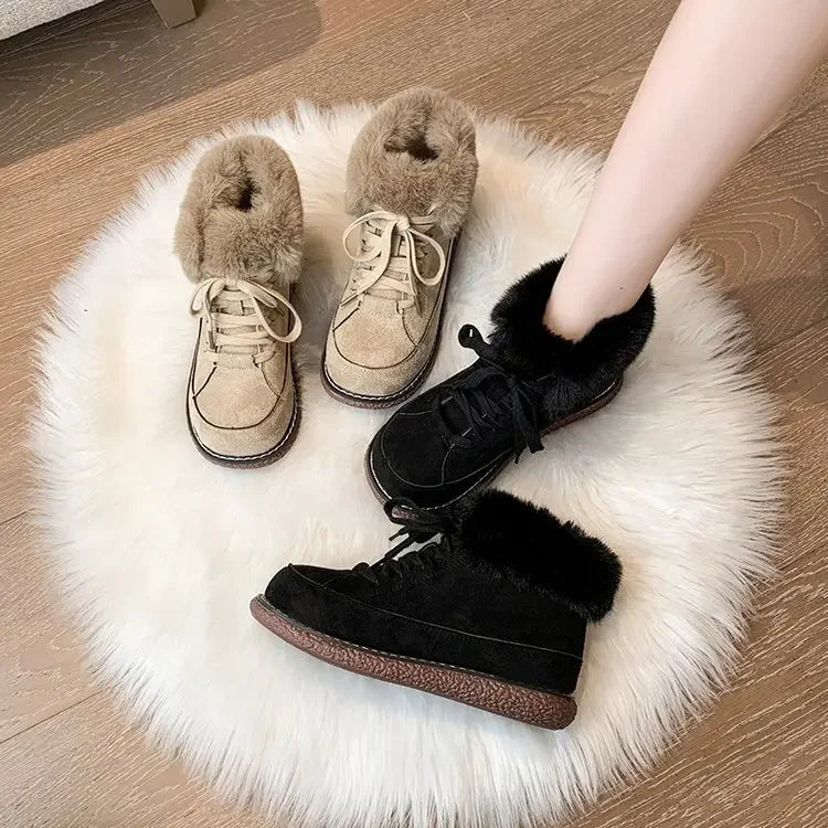 Faux fur-lined winter boots in beige and black on a white rug, showcasing cozy, stylish footwear for cold weather. Fashionable women's shoes.