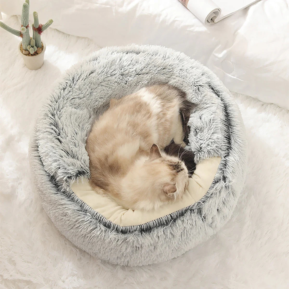 Fluffy gray cat bed with sleeping cat, plush round pet bed, cozy and soft for cats.