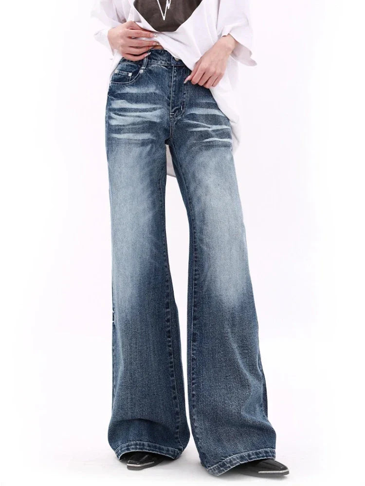 Wide-leg distressed denim jeans with a high waist, featuring a faded wash and subtle whiskering. Perfect for casual fashion and street style trends.