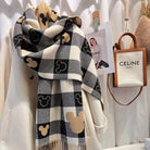 Stylish black and white checkered scarf with beige Mickey Mouse patterns, draped over a white coat, next to a Celine Paris handbag.