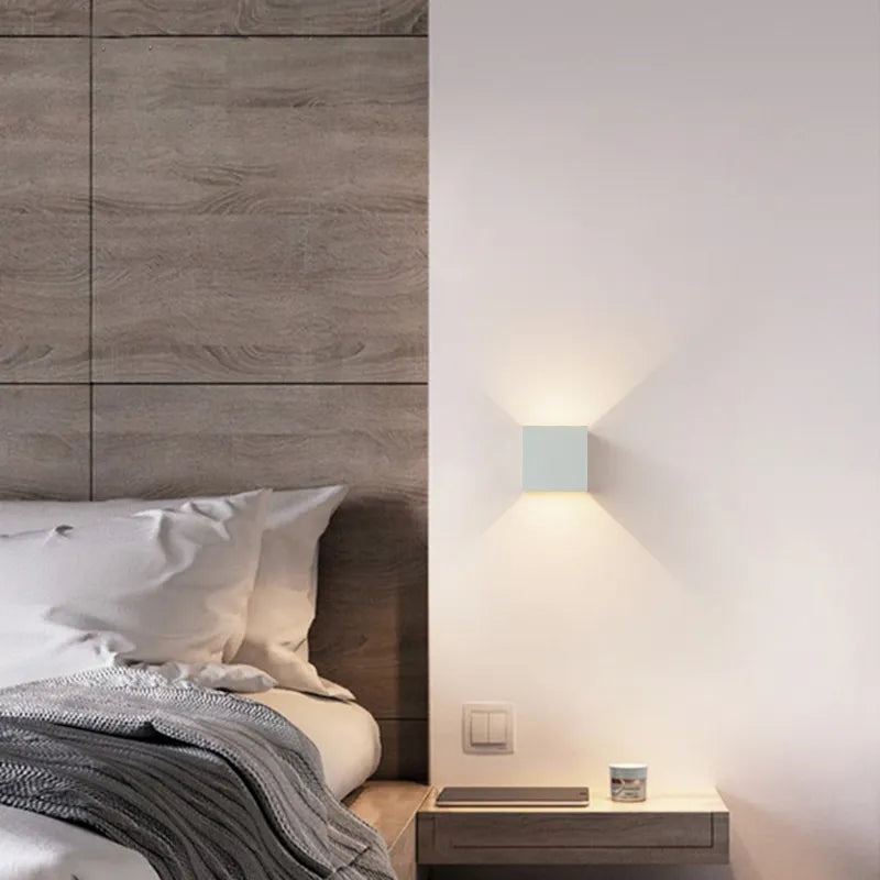 Modern bedroom with wooden headboard, cozy bedding, and minimalist wall sconce lighting. Stylish interior design, contemporary home decor.