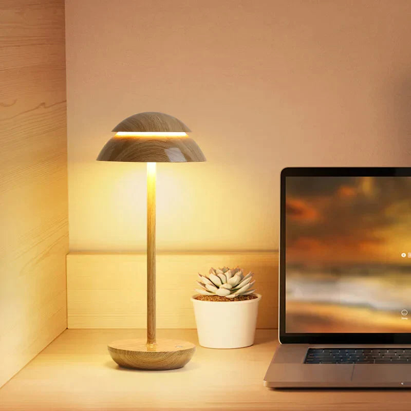 Modern wooden table lamp with warm LED light, minimalist design, next to a laptop and succulent plant on a wooden desk. Perfect for home office decor.