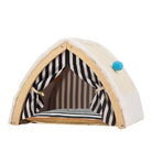 Cozy pet tent with striped interior, beige exterior, and blue pom-pom accent. Ideal for small pets. Portable, stylish pet shelter for indoor use.