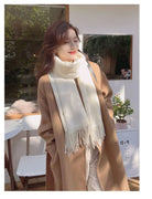 Woman in a stylish brown coat and white scarf standing outdoors, exuding autumn fashion vibes. Perfect for cozy fall outfit inspiration.