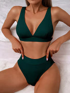 Emerald green bikini set with high-waisted bottoms and deep V-neck top, perfect for summer beachwear. Stylish swimwear for women.