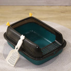 Teal and black cat litter box with scoop on a rug, featuring a removable top and ventilation slots.