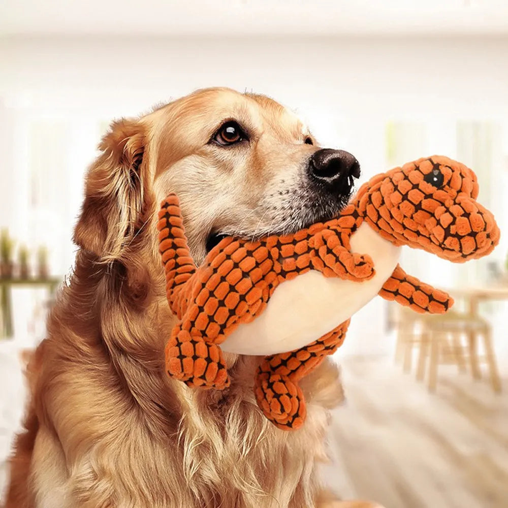 Golden Retriever holding an orange dinosaur plush toy in a bright living room. Cute dog with stuffed animal, pet-friendly home decor.