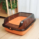 Orange and brown enclosed cat litter box with high sides on wooden floor.