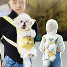 Small white dog in a yellow pet carrier backpack worn by a person, showcasing a convenient and stylish way to carry pets. Perfect for dog lovers.