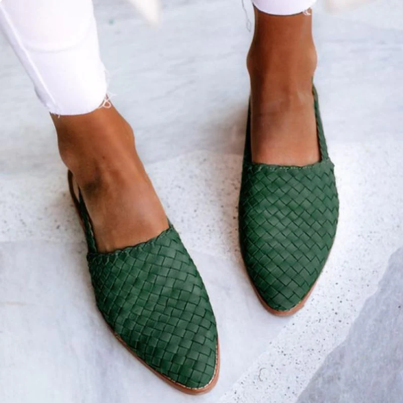 Green woven leather flats on feet, stylish women's slip-on shoes, casual footwear, fashion-forward design, perfect for summer outfits.