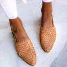 Woven leather slip-on flats for women, featuring a stylish tan design. Perfect for casual wear, these comfortable shoes complement any outfit.