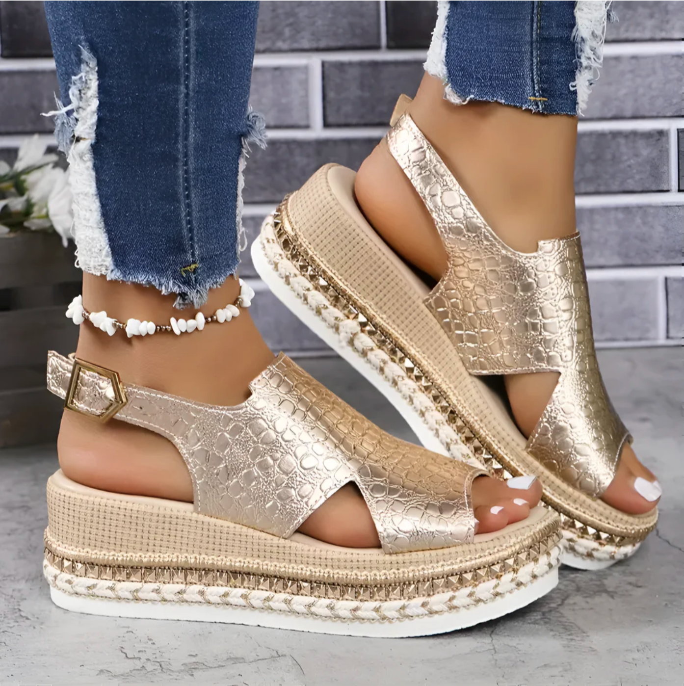 Gold platform sandals with textured design, open toe, and ankle strap, paired with distressed jeans. Fashionable summer footwear for women.