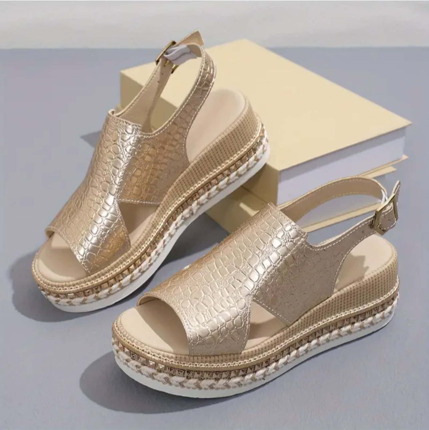 Gold platform sandals with textured crocodile pattern, open toe design, and adjustable ankle strap, placed on a neutral background. Fashion footwear.