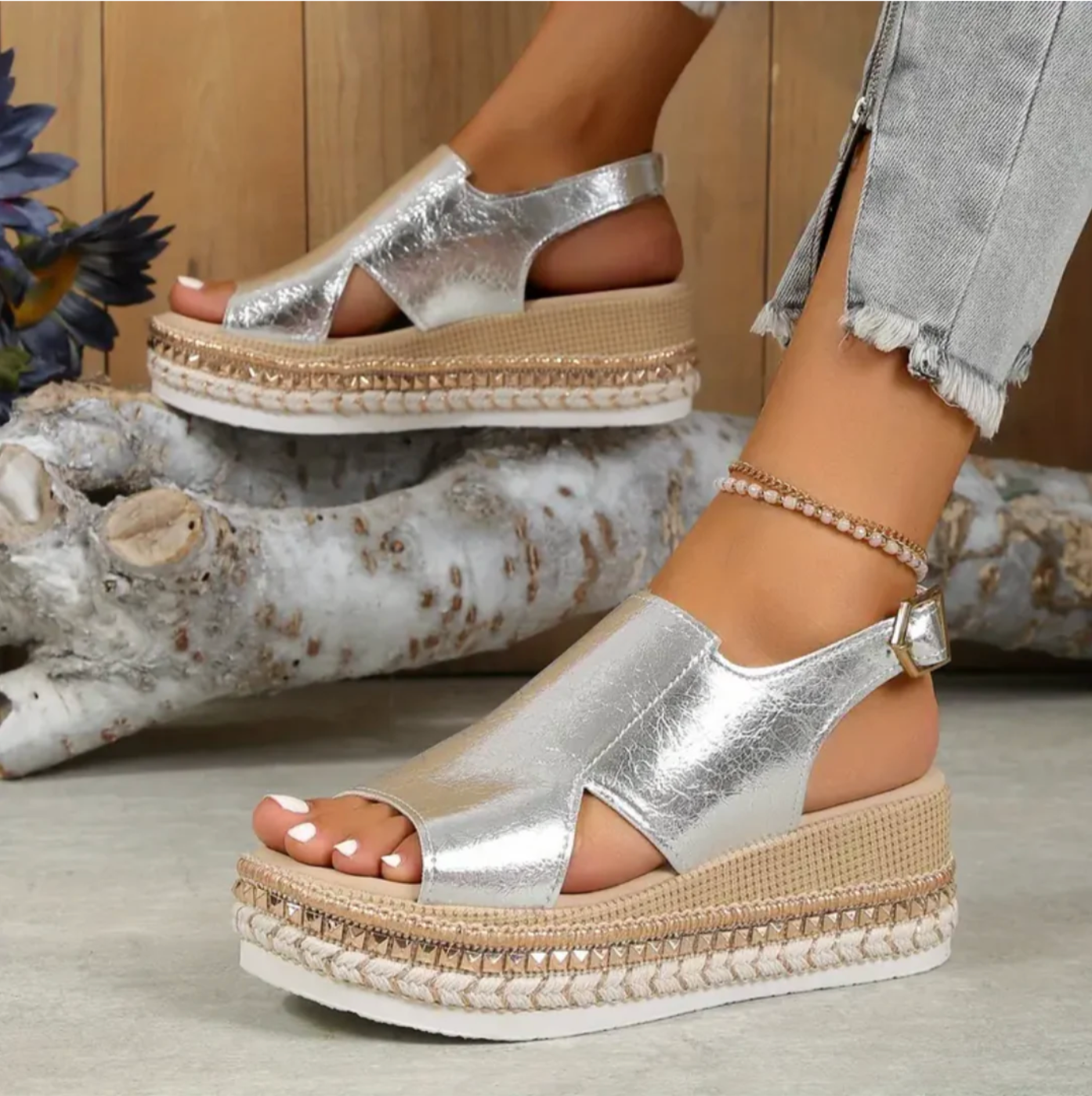 Silver platform sandals with open toe design, featuring woven espadrille sole and ankle strap, styled with frayed hem jeans. Fashion footwear.