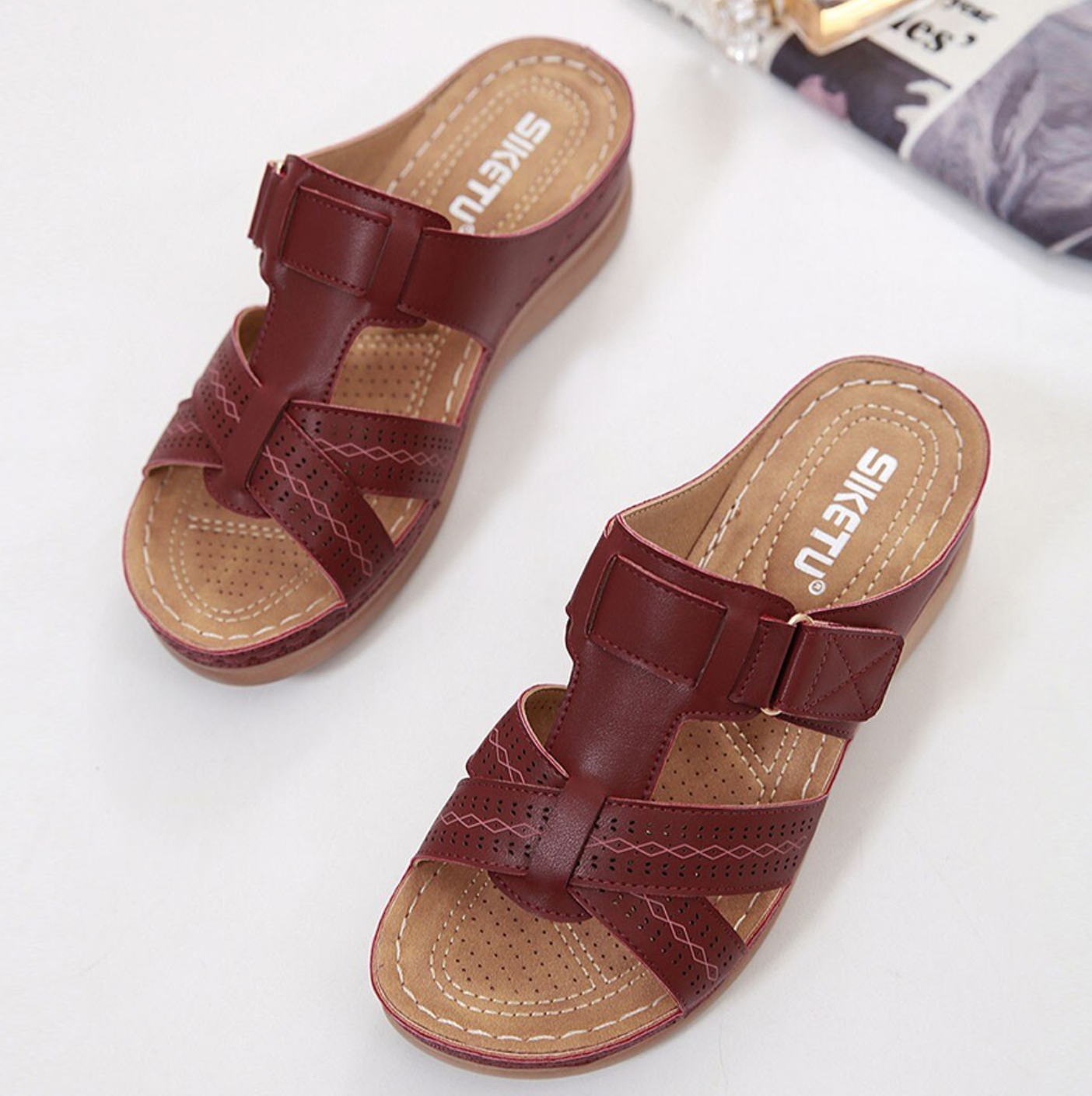 Women's brown leather slip-on sandals with cushioned sole, featuring cross-strap design and perforated details, ideal for casual summer wear.