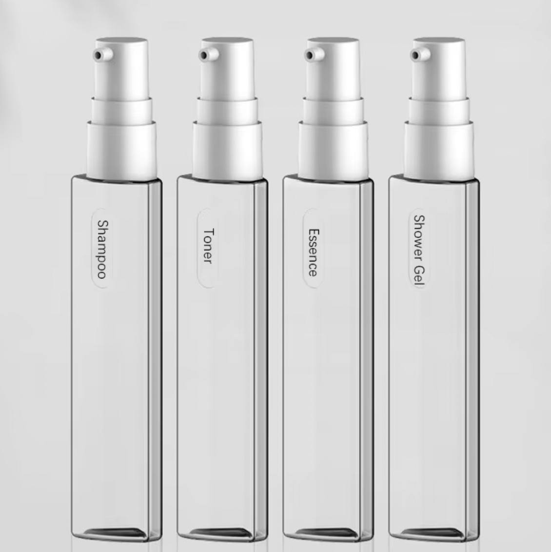 Clear plastic spray bottles labeled Shampoo, Toner, Essence, and Shower Gel, ideal for travel or personal care, minimalist design, white caps.