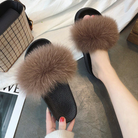 Fluffy brown fur slides on black soles, stylish women's footwear, cozy indoor slippers, fashion accessories, comfortable slip-on shoes.