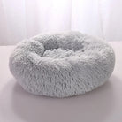 Fluffy gray round pet bed with soft plush fabric, ideal for cats and small dogs, providing comfort and warmth. Perfect cozy sleeping spot.