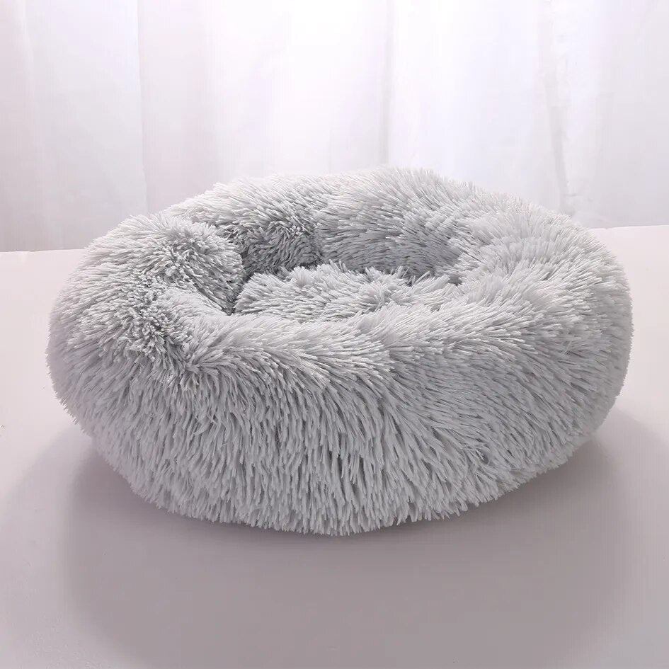 Fluffy gray round pet bed with soft plush fabric, ideal for cats and small dogs, providing comfort and warmth. Perfect cozy sleeping spot.