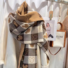 Checkered scarf with Mickey Mouse pattern in brown and beige tones, draped over a white coat, next to a Celine Paris handbag on a rack.