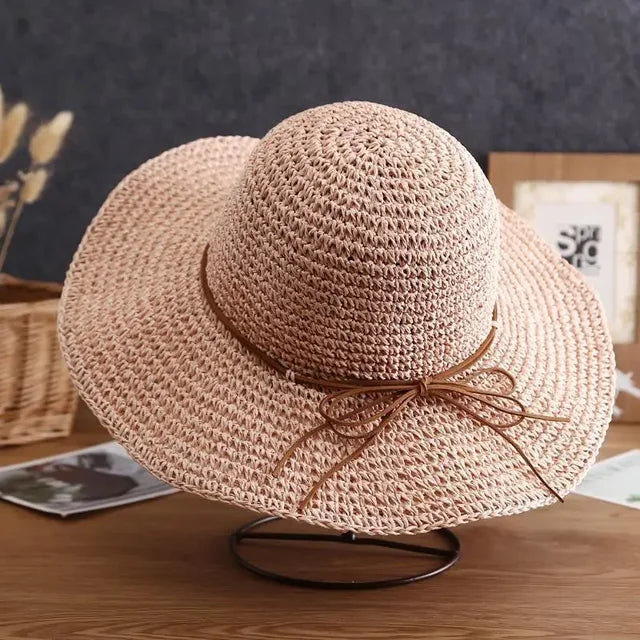 Wide-brimmed straw sun hat with a decorative bow, perfect for summer beach outings. Women's stylish sun protection hat, lightweight and breathable.