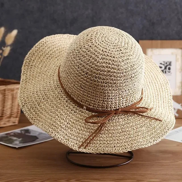 Straw sun hat for women with wide brim and brown ribbon, perfect for beach outings and summer fashion. Lightweight, breathable, and stylish accessory.
