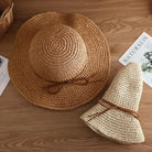 Wide-brimmed straw sun hats for women on wooden table, featuring natural woven design and decorative bow, perfect for summer beachwear.