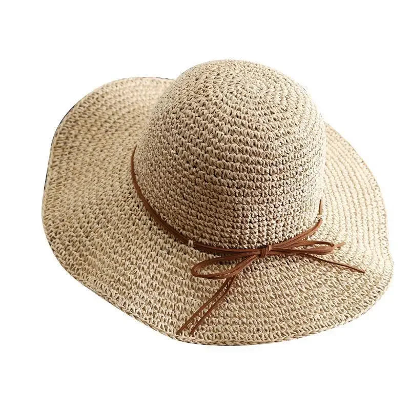 Wide-brimmed straw sun hat for women with brown ribbon, perfect for summer beach outings, offering stylish sun protection and casual elegance.