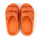 Orange thick sole slippers with double buckle design, textured surface, ideal for women, home or outdoor use. Comfortable, stylish footwear.