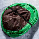 Interactive cat toy with green and brown fabric, folded and secured with a black strap, ideal for engaging feline play and stimulation.