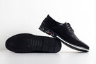 Black leather men's dress shoes with textured sole, lace-up design, and sleek finish. Perfect for formal occasions. High-quality footwear.