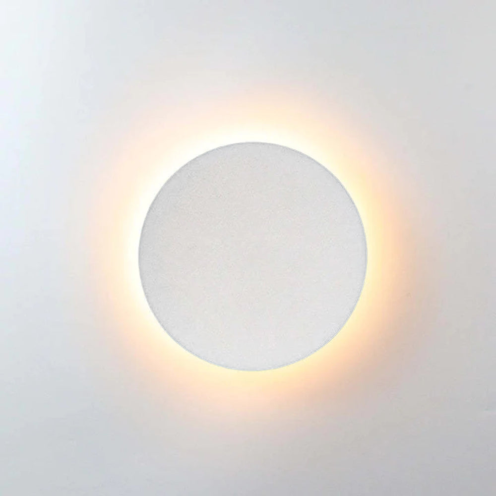 Modern circular wall light with warm LED glow, minimalist design, white finish. Ideal for contemporary home decor and ambient lighting solutions.