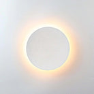 Modern circular wall light with warm LED glow, minimalist design, white finish. Ideal for contemporary home decor and ambient lighting solutions.